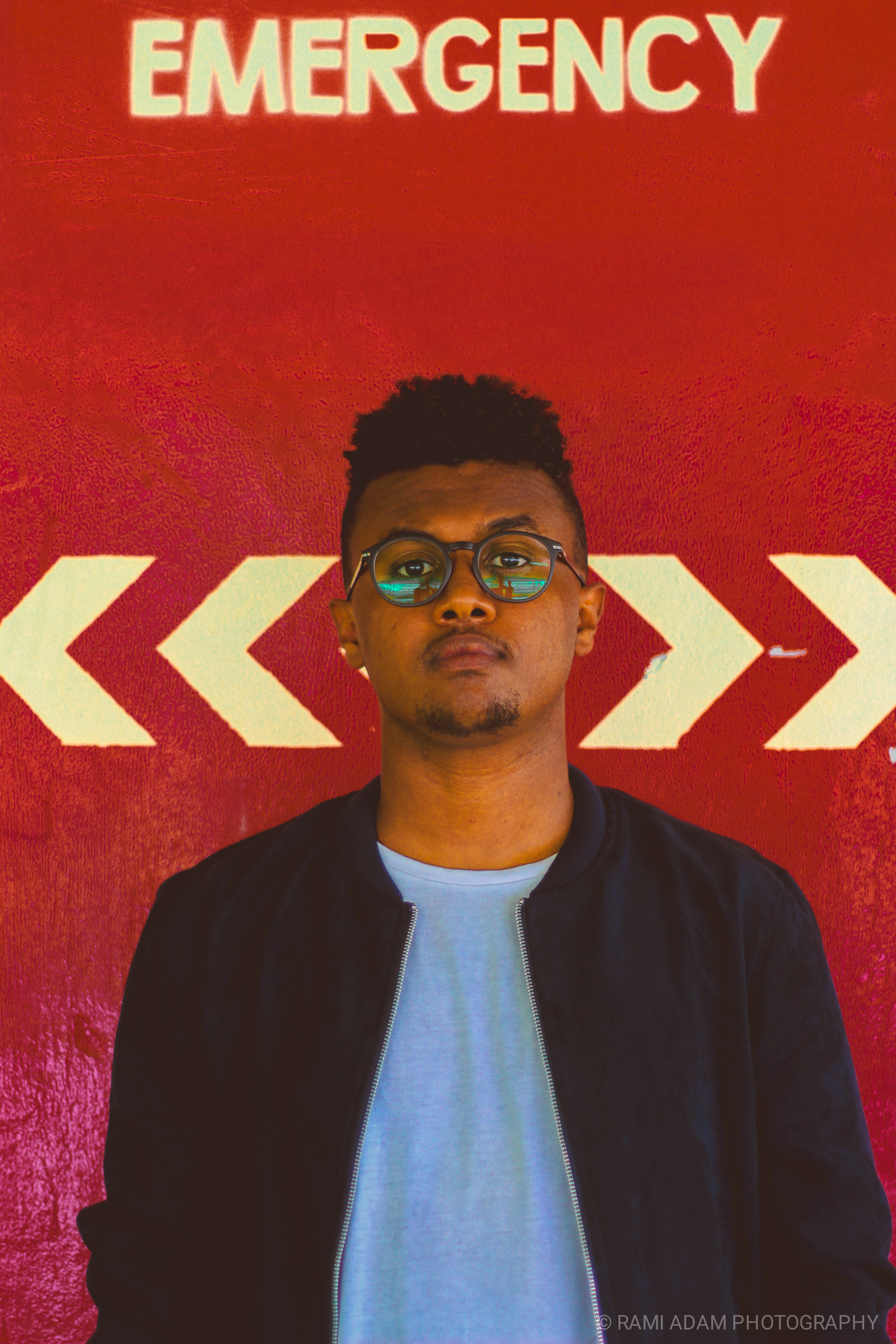 Man in front of red Emergency sign